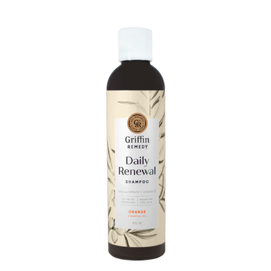 A bottle of Griffin Remedy Daily Renewal Shampoo with a label featuring botanical illustrations and the scent marked as Orange. Natural hair care.