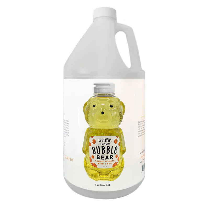 A gallon bottle in the shape of a teddy bear with a yellow bubble bath inside, labeled 'Griffin Remedy Bubble Bear Orange Blossom Bubble Bath'. Natural skincare.