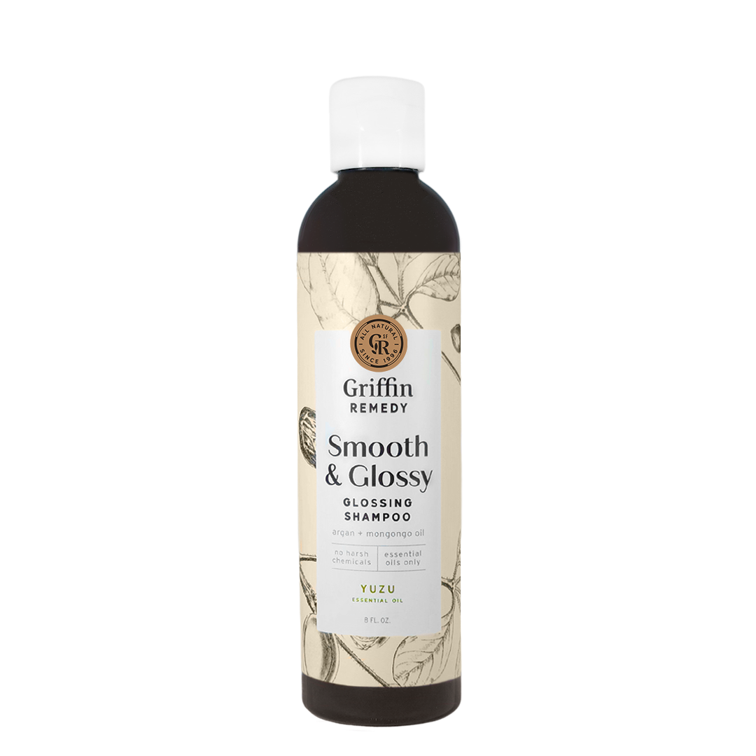 A bottle of Griffin Remedy Smooth & Glossy Shampoo with a label featuring botanical illustrations. Natural hair care.