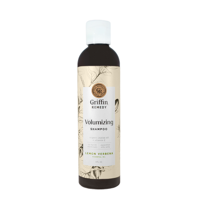 A bottle of Griffin Remedy Volumizing Shampoo with a label featuring botanical illustrations and text indicating the product name and scent, Lemon Verbena. Natural hair care.