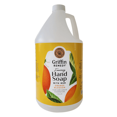 A gallon-sized bottle of Griffin Remedy Foaming Hand Soap with Orange Blossom. The bottle is yellow with a picture of orange blossoms and leaves on it. Natural soap.
