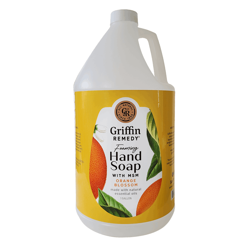 A gallon-sized bottle of Griffin Remedy Foaming Hand Soap with Orange Blossom. The bottle is yellow with a picture of orange blossoms and leaves on it. Natural soap.