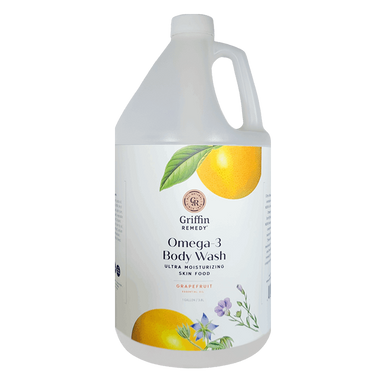 A gallon-sized bottle of Griffin Remedy Omega-3 Creamy Body Wash with a label featuring a grapefruit and flowers. Natural skincare.