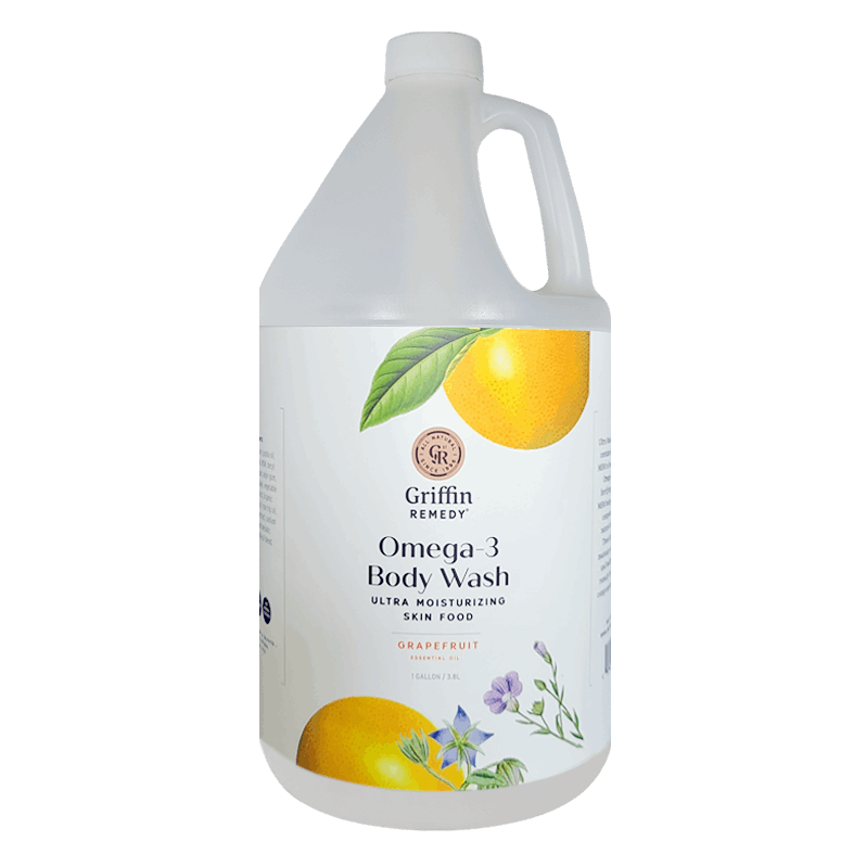 A gallon-sized bottle of Griffin Remedy Omega-3 Creamy Body Wash with a label featuring a grapefruit and flowers. Natural skincare.