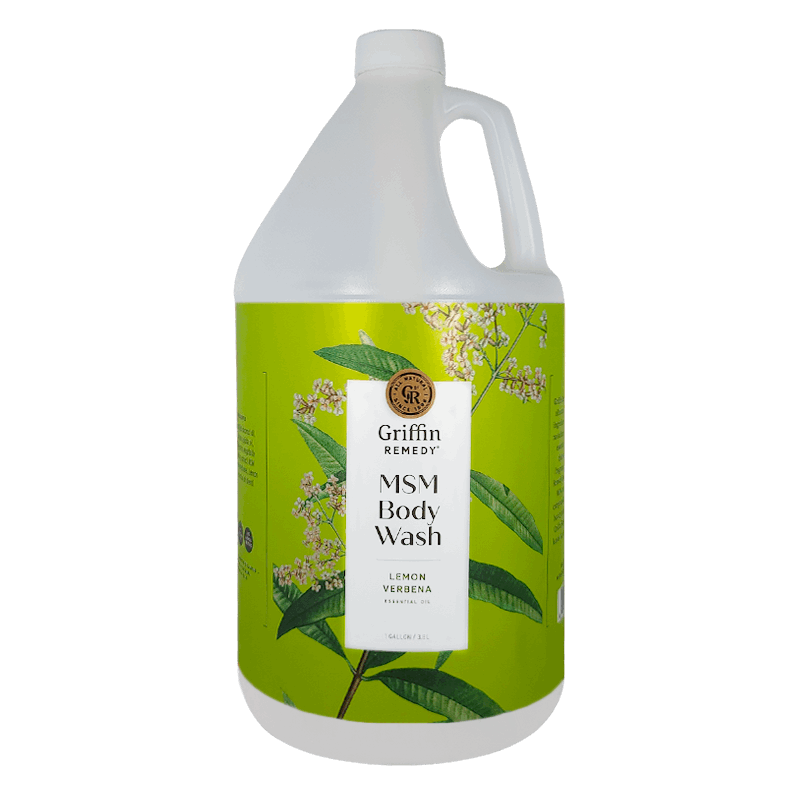 A gallon-sized bottle of Griffin Remedy MSM Body Wash with a green label featuring lemon verbena plants. Natural skincare.
