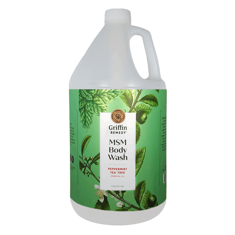 A gallon-sized bottle of Griffin Remedy MSM Body Wash with a green label featuring peppermint and tea tree illustrations. Natural skincare.