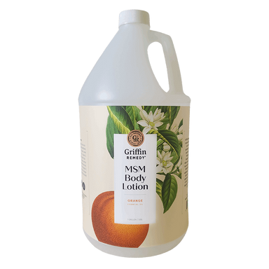 A gallon bottle of Griffin Remedy MSM Body Lotion with Orange Blossom scent, featuring a label with orange flowers and product information. Natural skincare.