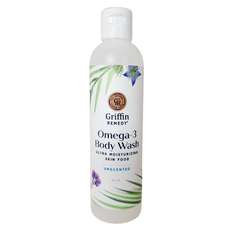 A bottle of Griffin Remedy Omega-3 Creamy Body Wash with a label that includes the product name and 'Unscented' beside it. The bottle is white with green and blue floral design accents. Natural skincare.