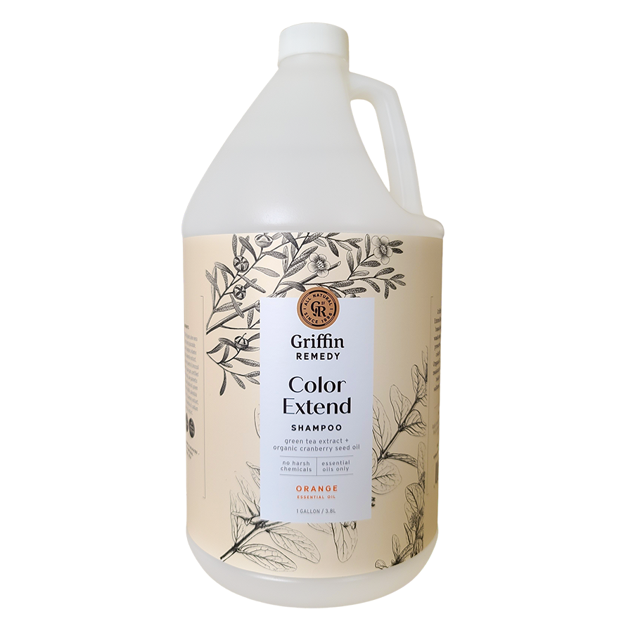 A gallon-sized bottle of Griffin Remedy Color Extend Shampoo with a floral pattern on the label and orange scent indicated on the front. Natural hair care.