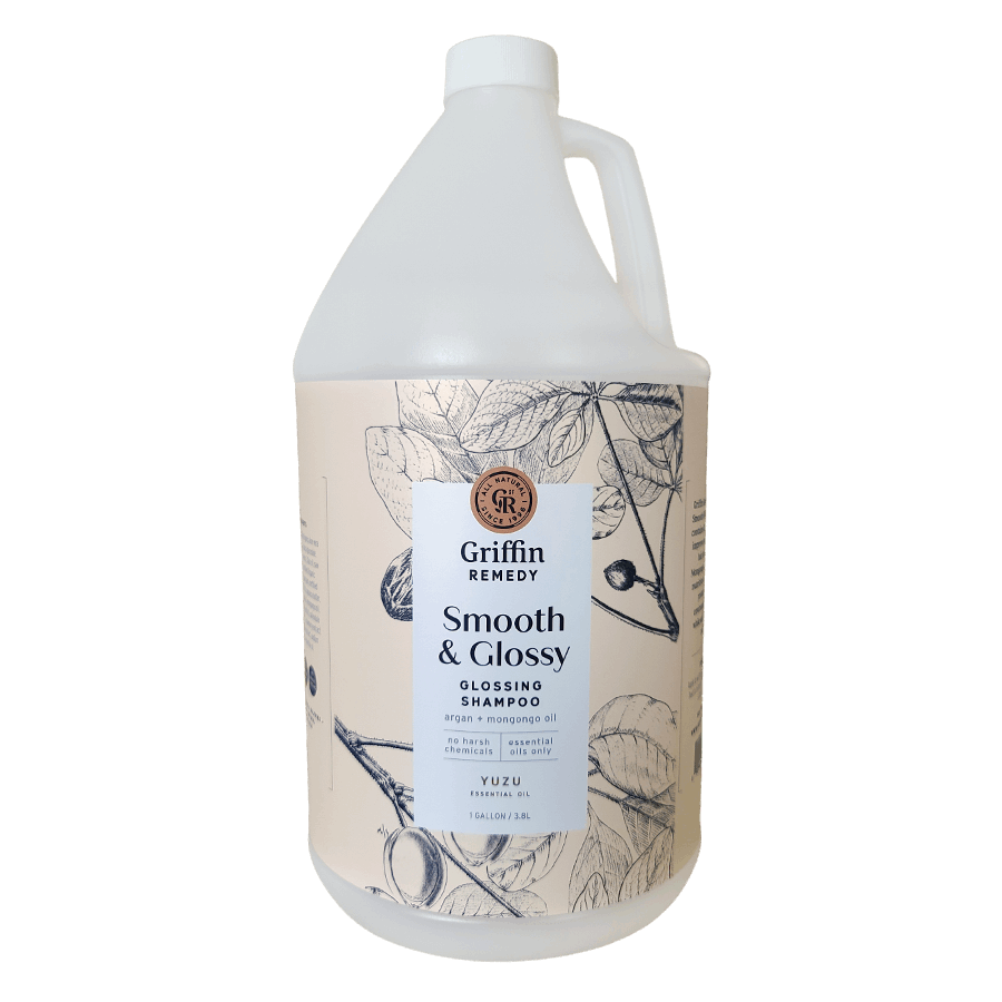 A gallon bottle of Griffin Remedy Smooth & Glossy Shampoo with a label featuring botanical illustrations. Natural hair care.