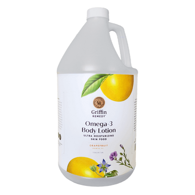 A gallon-sized bottle of Griffin Remedy Omega-3 Body Lotion with an image of a grapefruit on the label and various botanical illustrations. Natural skincare.