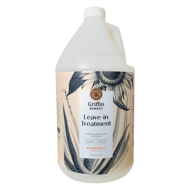 A gallon-sized bottle of Griffin Remedy Leave-In Treatment with a floral design on the label. Natural hair care.