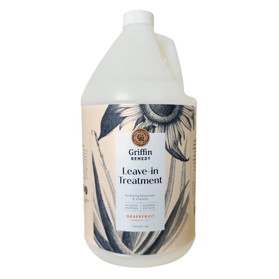 A gallon-sized bottle of Griffin Remedy Leave-In Treatment with a floral design on the label. Natural hair care.