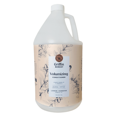 A gallon bottle of Griffin Remedy Volumizing Conditioner with a label featuring botanical illustrations and text. Natural hair care.