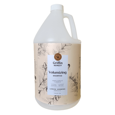 A gallon bottle of Griffin Remedy Volumizing Shampoo with a label featuring botanical illustrations and text indicating the product name and scent, Lemon Verbena. Natural hair care.