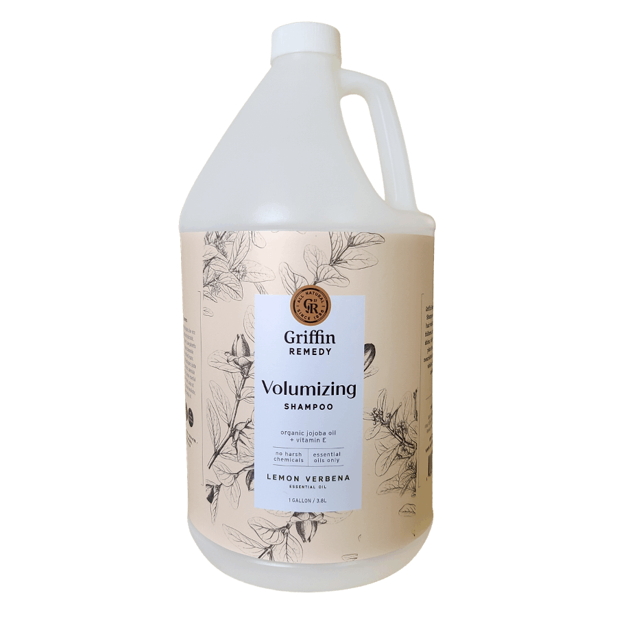 A gallon bottle of Griffin Remedy Volumizing Shampoo with a label featuring botanical illustrations and text indicating the product name and scent, Lemon Verbena. Natural hair care.
