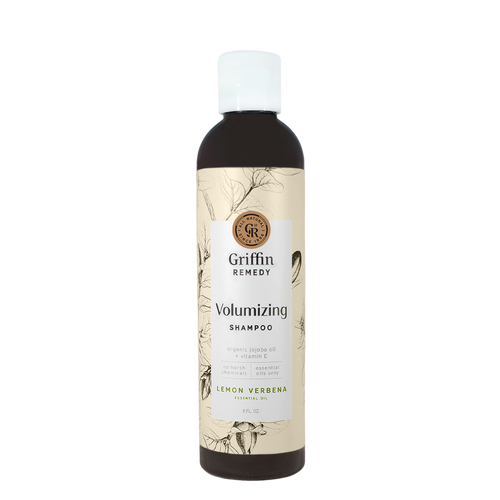A bottle of Griffin Remedy Volumizing Shampoo with a label featuring botanical illustrations and text indicating the product name and scent, Lemon Verbena. Natural hair care.