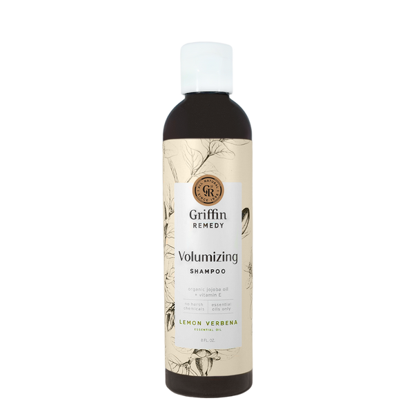 A bottle of Griffin Remedy Volumizing Shampoo with a label featuring botanical illustrations and text indicating the product name and scent, Lemon Verbena. Natural hair care.
